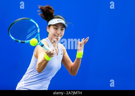 Xinyu Wang de Chine récupère la balle contre Kurumi Nara du Japon à la match de qualification des femmes simple de 2019 WTA Open de Wuhan à Wuhan, 100 Banque D'Images