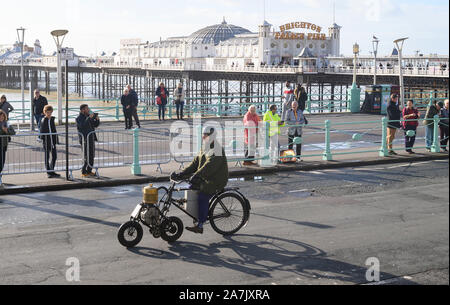 Brighton UK 3 Novembre 2019 - Un vélo passe par le Palace Pier de Brighton qu'il s'approche de la finale de l'Bonhams Londres à Brighton Veteran Car Run. Plus de 400 voitures pré-1905 est parti de Hyde Park Londres tôt ce matin et finir à Brighton's Madeira Drive sur le front du Crédit : Simon Dack / Alamy Live News Banque D'Images