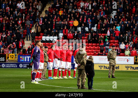 Charlton Athletic les joueurs avec des membres des forces armées au cours d'une minutes de silence avant le match de championnat à Sky Bet La Vallée, Charlton. Banque D'Images