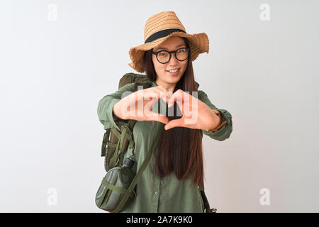 Randonneur chinois woman wearing hat cantine verres sac à dos sur fond blanc isolé en souriant aime faire symbole coeur forme avec les mains. Romantic Banque D'Images