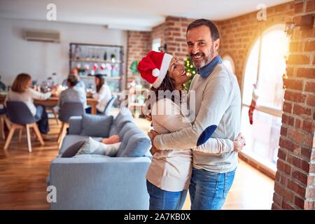 La famille et les amis des repas maison pour célébrer la veille de Noël avec de la nourriture traditionnelle et la décoration, romantic senior couple hugging in love Banque D'Images