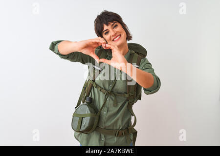 Randonneur belle femme portant un sac à dos et de l'eau sur fond blanc isolé cantine smiling in love montrant le symbole de coeur et la forme des mains. Rom Banque D'Images