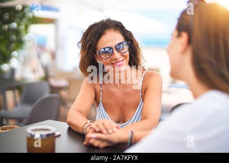 Belle Mère et fille assis à une terrasse de restaurant parlant et souriant Banque D'Images
