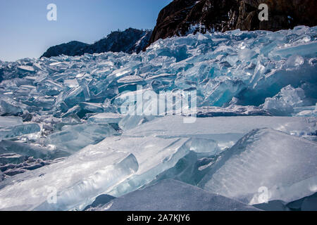 De nombreux morceaux de tempête de glace dans un grand tas à côté de la roche. Journée ensoleillée, la glace brille au soleil. Ice Blue et vert. Banque D'Images