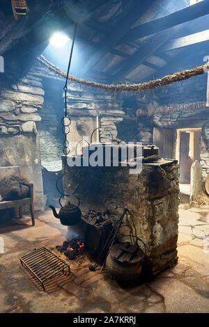 Intérieur de l'Kirbuster Farm Museum, un firehoose, montrant la pierre centrale âtre, feu de tourbe et pendaison électrique, Kirbuster, Mainland, Orkney, Scotl Banque D'Images