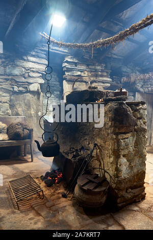 Intérieur de l'Kirbuster Farm Museum, un firehoose, montrant la pierre centrale âtre, feu de tourbe et pendaison électrique, Kirbuster, Mainland, Orkney, Scotl Banque D'Images