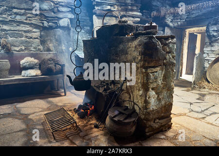 Intérieur de l'Kirbuster Farm Museum, un firehoose, montrant la pierre centrale âtre, feu de tourbe et pendaison électrique, Kirbuster, Mainland, Orkney, Scotl Banque D'Images