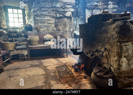 Intérieur de l'Kirbuster Farm Museum, un firehoose, montrant la pierre centrale âtre, feu de tourbe et pendaison électrique, Kirbuster, Mainland, Orkney, Scotl Banque D'Images