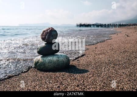 Pile de pierres zen sur plage près de la mer. Tour de roches spa sur le sable à l'océan. Cailloux équilibré extérieur dès les beaux jours d'été. Le calme et l'harmonie s'Orient Banque D'Images