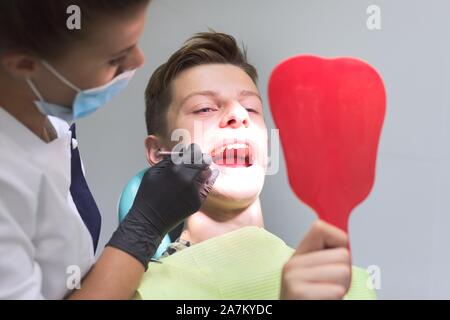 Femme médecin dentiste dents gâteries à teenage boy Banque D'Images