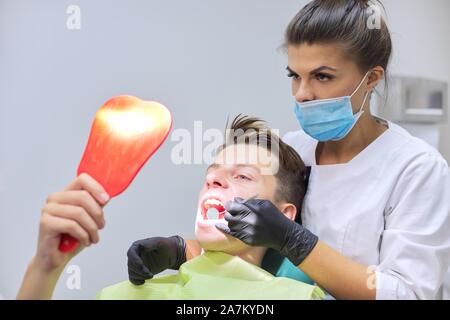 Femme médecin dentiste dents gâteries à teenage boy Banque D'Images