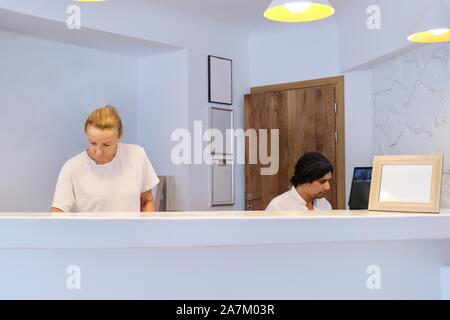 Portrait de l'hotel travailleurs au travail, l'homme et la femme près de réceptionnistes/24 Banque D'Images