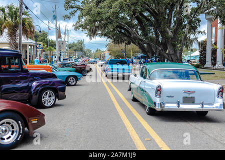 Une rue principale Car Show avec voitures en stationnement sur les côtés et à l'alimentation de la conduite sur route. Banque D'Images