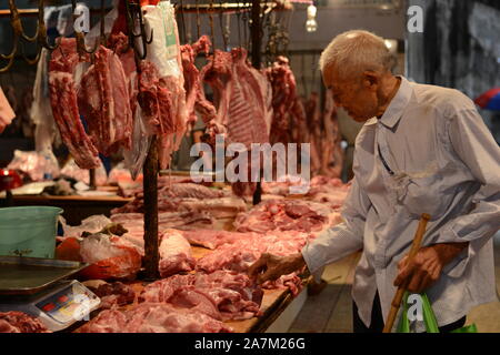 Un client chinois achète la viande de porc et d'autres produits à un marché libre du comté de Yunyang, Chongqing, Chine, 31 août 2019. La Chine prendra des mesures Banque D'Images