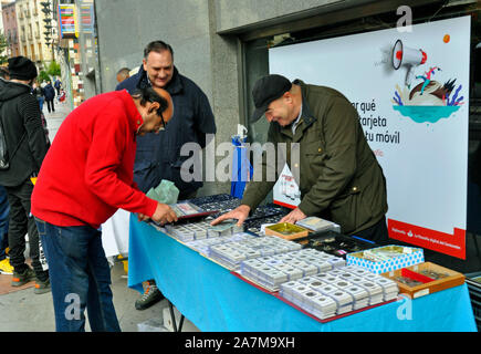 Un commerçant de la rue des pièces en vente sur le marché du centre-ville de Grenade, Espagne Banque D'Images