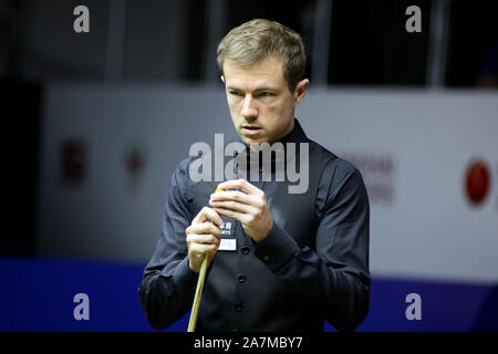 Jack Lisowski d'Angleterre les craies son cue qu'il estime un tir de Mark Selby, d'Angleterre, au deuxième tour de 2019 Snooker Shanghai Masters en Shangh Banque D'Images