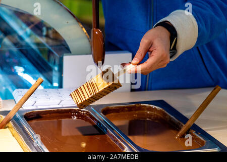 Ice lolly étant trempé dans du chocolat à Loco Polo, San Sebastian, Espagne Banque D'Images