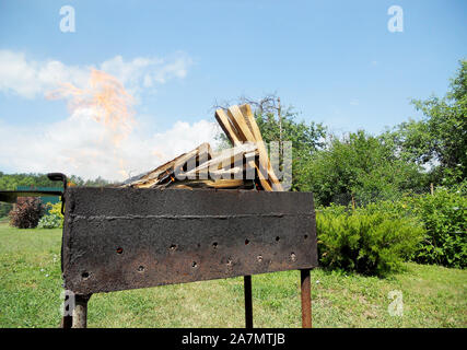 Belle coupe de feu rouge, bois noir gris foncé à l'intérieur de charbons metal brazier. La combustion du bois dans le brasero sur feu jaune vif. Feux flammes prepar Banque D'Images