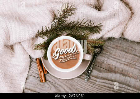 La tasse de café chaud avec une couverture chaude sur une table en bois avec décorations Banque D'Images