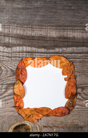 Feuille de papier vierge sur un bois avec les feuilles d'automne et décorations Banque D'Images