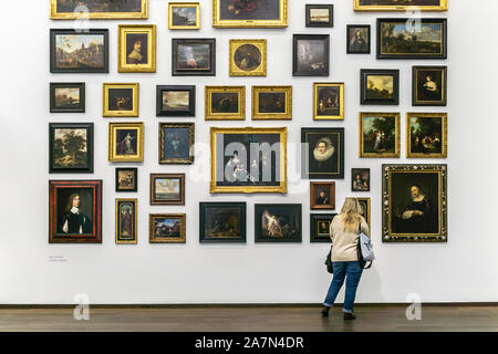 Bilderlust avec beaucoup d'exposition d'art de peintures accroché sur un mur blanc et un visiteur à les regarder, Musée d'Art de Bâle, Suisse. Banque D'Images