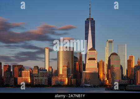 Coucher du soleil sur le Lower Manhattan gratte-ciel du quartier financier (World Trade Center) de la rivière Hudson. Lower Manhattan, New York, NY, US