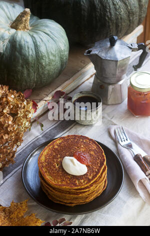 Crêpes à la citrouille avec crème et de la confiture sur un fond d'automne de la vie encore. Banque D'Images
