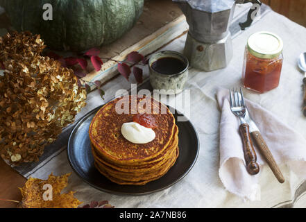 Crêpes à la citrouille avec crème et de la confiture sur un fond d'automne de la vie encore. Banque D'Images