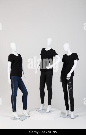 Trois mannequins féminins vêtus de vêtements noirs à la mode sur fond blanc. Banque D'Images