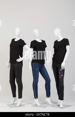 Trois mannequins féminins vêtus de vêtements noirs à la mode sur fond blanc. Banque D'Images