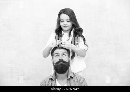 Changer de coiffure. Créer drôle de coiffure. Avec bonne dose d'ouverture n'importe quel père peut exceller à sensibiliser le jeune fille. Enfant faisant hairstyle styling père barbe. Être parent signifie présenter pour leurs intérêts. Banque D'Images