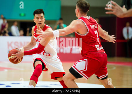Guo Ailun, un joueur de basket-ball chinois professionnel, gauche, tente de se rompre pendant 2019 Zhouzhuang Tasse Kunshan Men's International Basket-ball Champi Banque D'Images