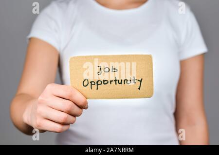 Phrase de possibilité d'emploi à la main sur papier carton carré holding par les jeunes femmes de race blanche dans la main droite. Banque D'Images