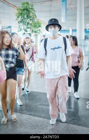 L'acteur et chanteur chinois Zhang Yuan, au blanc, arrive à l'aéroport international Beijing Capital avant le départ à Beijing, Chine, 18 Août Banque D'Images