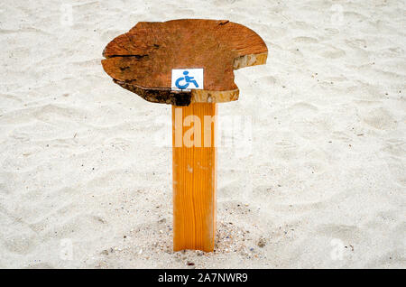 Poteau en bois peint avec signe qui indique que cette partie de plage est pour les personnes handicapées . Banque D'Images