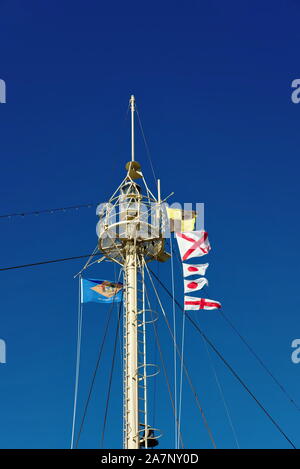 Mât de signalisation et feu à éclats du navire lumineux OverFalls, amarré à Lewes, Delaware. Le drapeau de l'État du Delaware et les drapeaux de signalisation volent dans la brise. Banque D'Images