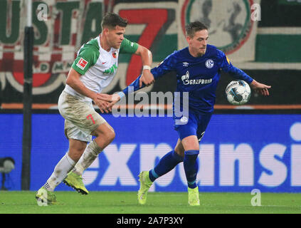 Augsburg, Allemagne. 29Th sep 2019. Bastian Oczipka (R) de Schalke 04 rivalise avec Florian Niederlechner d'Augsbourg au cours d'un match de Bundesliga allemande entre FC Augsburg et le FC Schalke 04 à Augsburg, Allemagne, le 3 novembre 2019. Crédit : Philippe Ruiz/Xinhua/Alamy Live News Banque D'Images