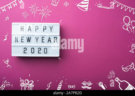 Bonne année 2020 avec boîte à lumière de l'article parti doodle fête décoration vacances point vue de dessus sur fond violet table avec copie espace.maquette banne Banque D'Images