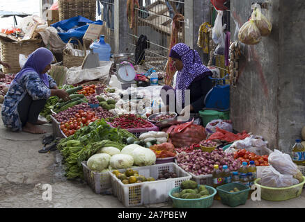 Labuanbajo, Indonésie - Août 17, 2015 : groupe de femmes portant le hijab et vente de vêtements traditionnels dans la rue de fruits tropicaux Banque D'Images