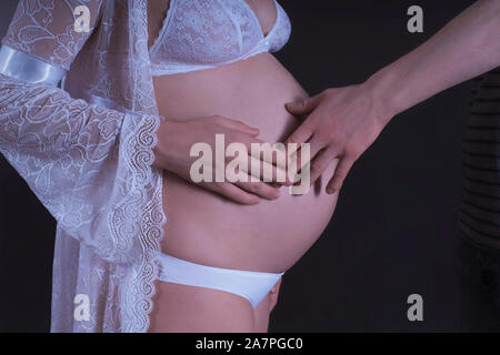 Un homme touche et embrasse le ventre de sa femme enceinte au cours de la marche. Libre.fille enceinte. Un homme touche le ventre d'une fille enceinte Banque D'Images