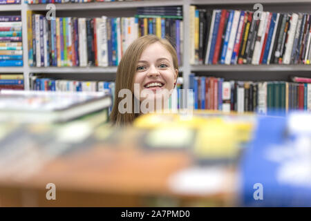 Manille, Philippines - juin, 14, 2017 : Smiling young woman girl choosing tenant un livre dans la bibliothèque ou la librairie Banque D'Images