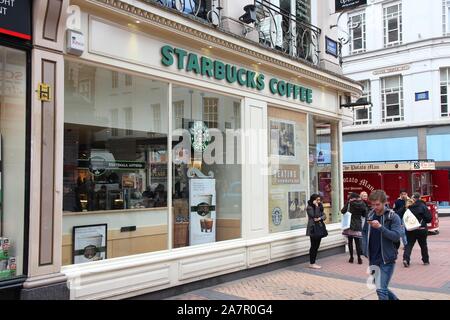 BIRMINGHAM, UK - 19 avril 2013 : les gens à pied par du café Starbucks Cafe à Birmingham, Royaume-Uni. Starbucks Corporation exploite 23 768 endroits dans le monde entier. Banque D'Images