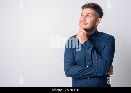 Portrait of happy young handsome businessman thinking persan Banque D'Images