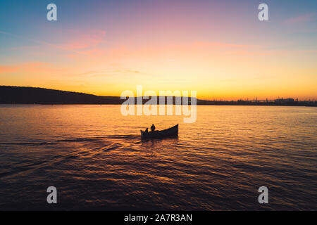 Coucher de soleil sur le bateau de pêche et d'or brillant de l'eau de mer. Banque D'Images
