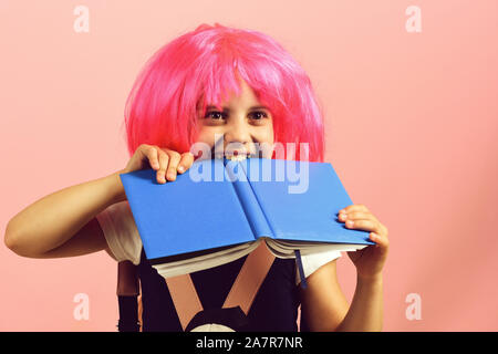 Fille de moustiques gros livre bleu. Retour à l'école et l'éducation concept. Élève de l'uniforme scolaire avec perruque rose. Fille de l'école d'isolé sur fond rose. Banque D'Images