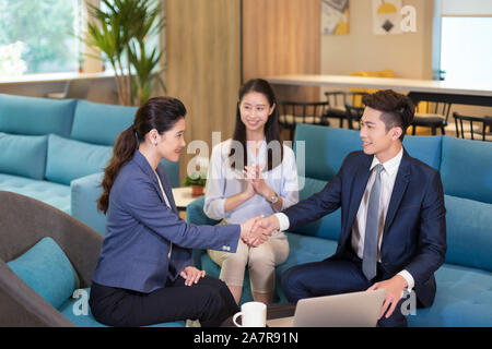 Photographie avec trois hommes et femmes d'affaires portant des businesswear avec deux d'entre eux shaking hands in office Banque D'Images