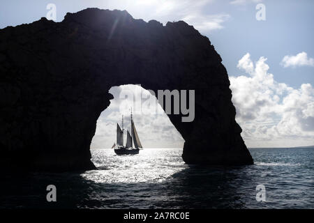 Le Tallship Moonfleet encadrées par l'Arch Rock de Durdle Door, Dorset, UK Banque D'Images