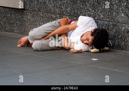 New York, USA - Le 23 juin 2019 : un jeune homme est allongé sur un trottoir pour piétons à Manhattan Banque D'Images