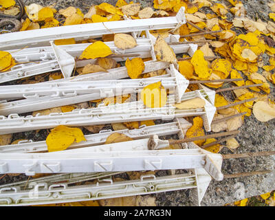 Poteaux en plastique prêt pour la construction d'une clôture électrique autour de paddock. Poteaux empilés dans le peuplier jaune feuilles sur le sol Banque D'Images