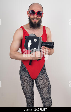 Crazy guy en rouge et Body leopard leggings posant avec une vieille caméra vidéo dans ses mains Banque D'Images